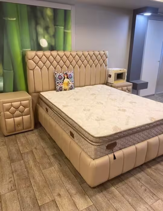 Beige fabric wingback bed set with matching upholstered bedside tables for a master bedroom